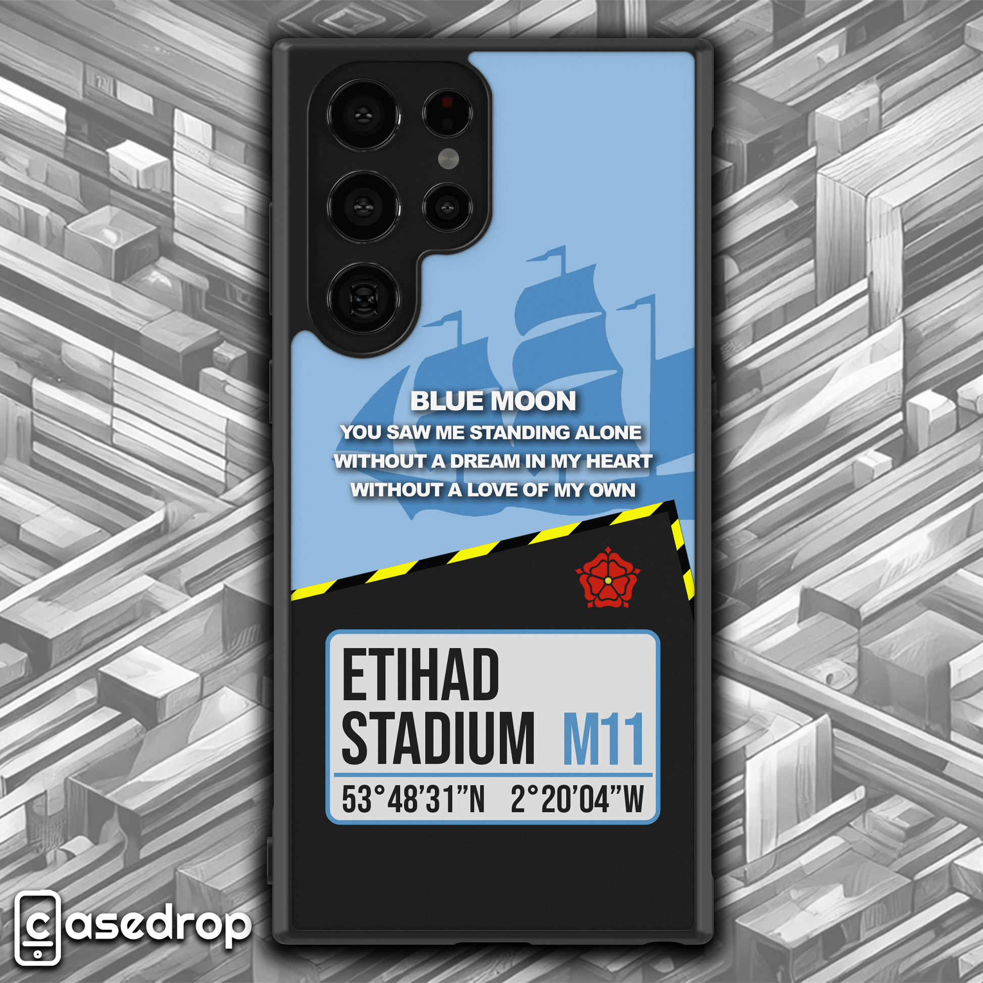 Close-up of Manchester City football phone case highlighting intricate sky blue design details, Etihad Stadium address, and 'Blue Moon' lyrics for football enthusiasts